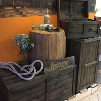 The rustic crate series 300 stained with onyx and set up as a retail wine display with driftwood and a barrel